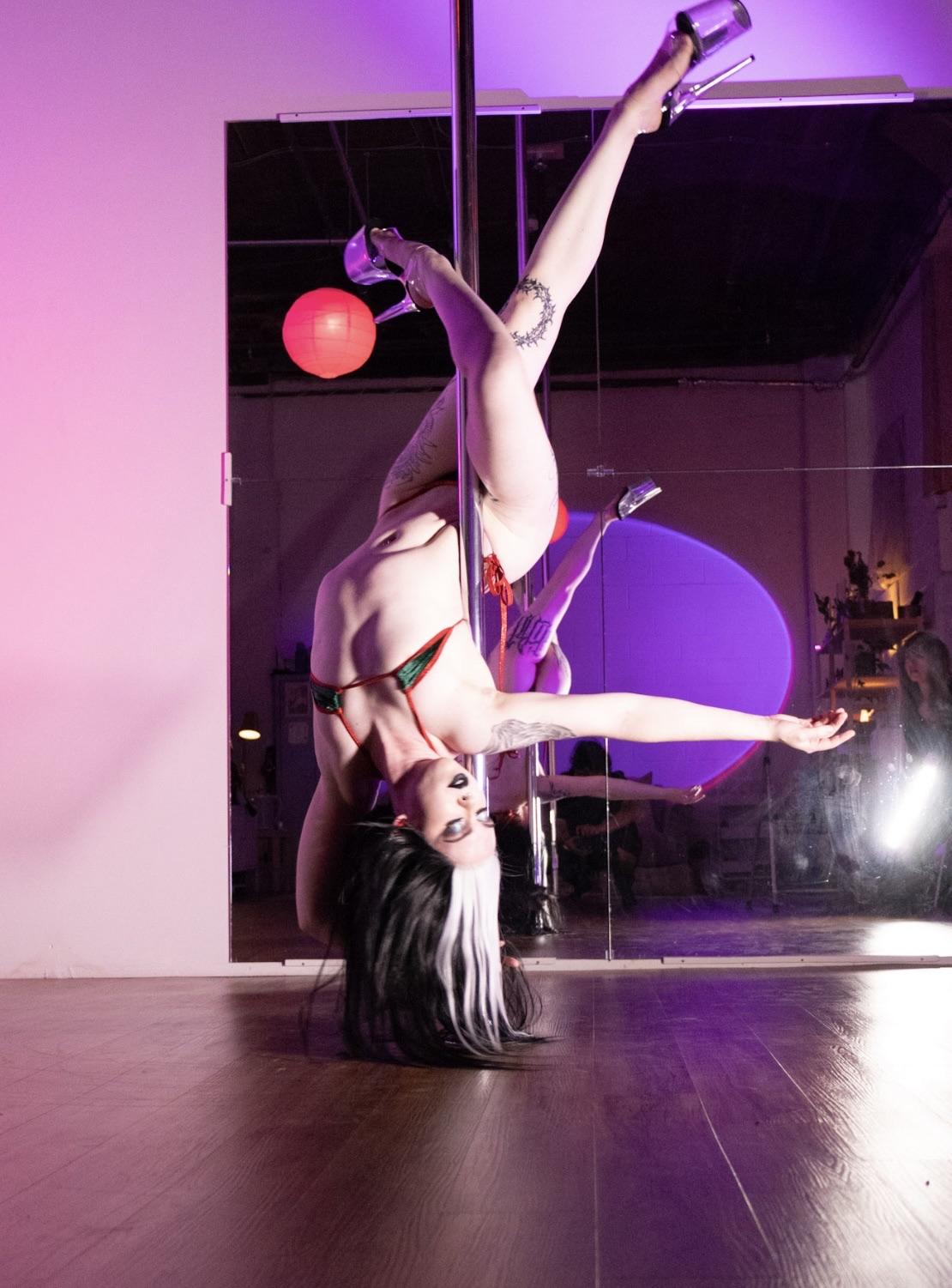 an image of bex doing a pole move called scorpio