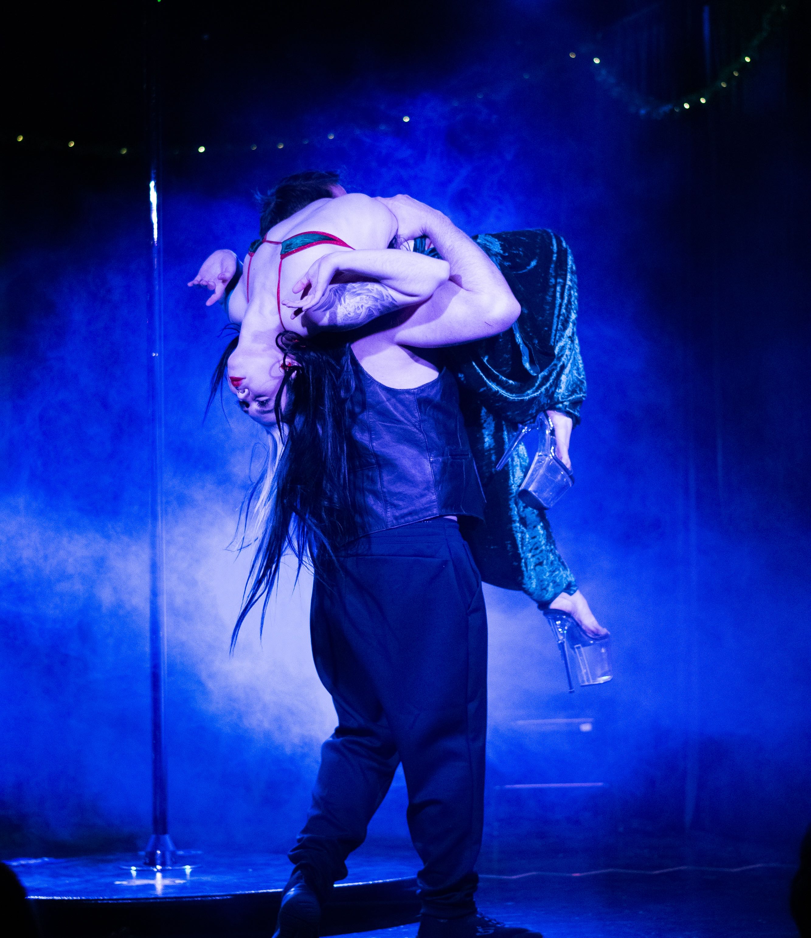 an image of bex being lifted backwards over a man's shoulder