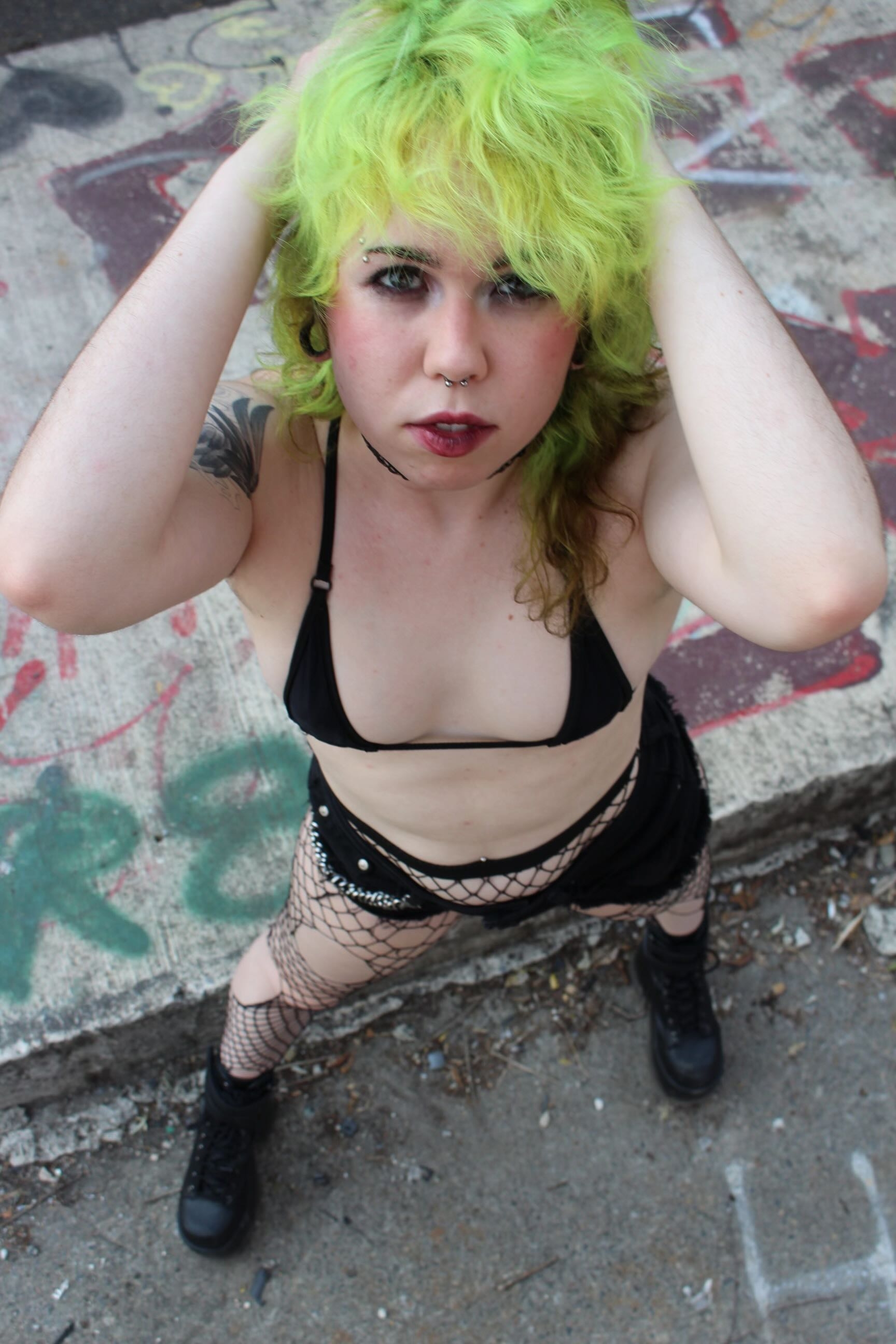 an image of bex looking up at the camera. he has green curly hair.